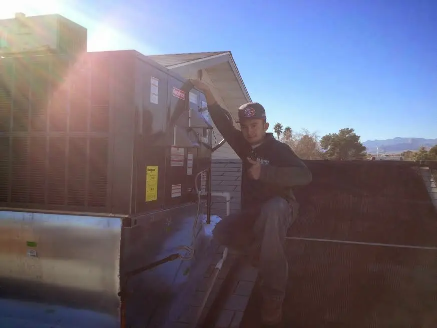 HVAC technician performing Heat Pump Repair on a rooftop unit in Greenwood